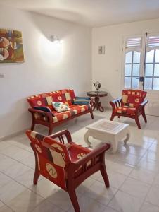 a living room with chairs and a couch and a table at Appartement au cœur de jambette in Saint-Joseph +1 photo