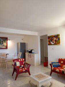 a living room with two chairs and a couch at Appartement au cœur de jambette in Saint-Joseph