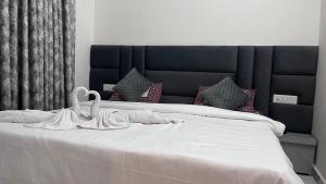 a large white bed with a black headboard and pillows at Millennium Suites - Comfy Rooms in Orchha +19 photos