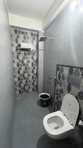 a bathroom with a white toilet in a room at Millennium Suites - Comfy Rooms in Orchha