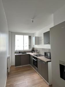a kitchen with stainless steel appliances and a window at Le Familial in Orléans