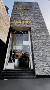 ルディヤーナーにあるHotel J Cruise Newの看板が掲げられた建物の正面玄関