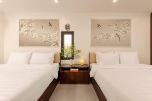 two beds in a room with white walls at Zen House Ninh Bình in Ninh Binh