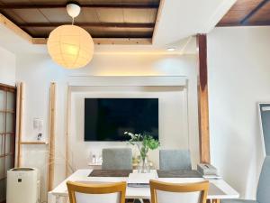 東京にある和みの宿Rent the whole houseのダイニングルーム(テーブル、椅子、テレビ付)