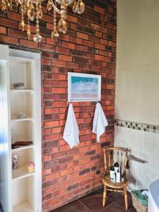a brick wall with towels hanging on a wall at Boschendal Guesthouse in Kimberley