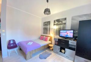 a small bedroom with a bed and a tv at STARE MiASTO II in Olsztyn
