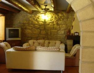 a living room with a couch and a stone wall at Casa El Rey in Murillo de Gállego