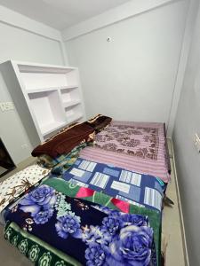 a bed with a quilt on it in a room at Mahadev Mahakumbh Homestay Inn in Jhūsi +5 photos