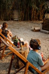 a group of children sitting in chairs with headphones at Ergon Beach House Nikiti in Nikiti