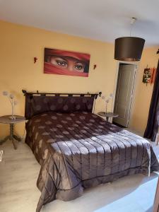 a bedroom with a bed with a painting on the wall at Chez Herveline Le Fer - Chambres et table d'hôtes in Plouigneau