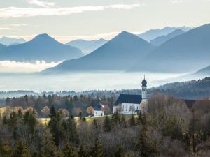 una iglesia en un valle con montañas en el fondo en Hotel Irschenberg Süd, en Irschenberg