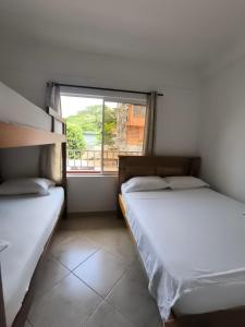 ネコクリにあるCasa Hotel Mar y Brisa Beachの窓のある部屋にベッドが2つある