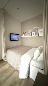 a bedroom with a bed and a tv on the wall at La Casa Avenida in Malmedy