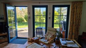 a living room with large glass doors and a chair at Haus an der Eiche in Wieck