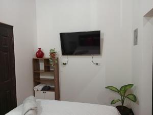 a bedroom with a flat screen tv on a wall at Apartment T46 in Antigua Guatemala
