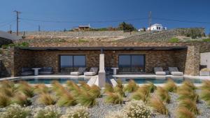 a villa with a swimming pool in front of a building at Syros Soul Private Pool Suites in Ermoupoli