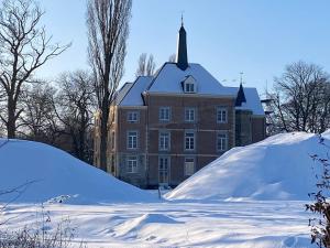 a large building with a pile of snow in front of it at BelleVie Apartment, Eijsden-Maastricht in Eijsden