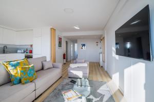 a living room with a couch and a table at Sunset Horizon Carcavelos in Carcavelos