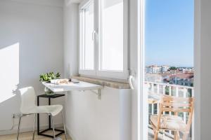 a white room with a table and a window at Sunset Horizon Carcavelos in Carcavelos
