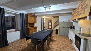 a kitchen with a black table and chairs in a room at Logis Montagnard in Modane