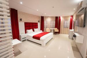 a bedroom with a bed and a red headboard at Hotel nord kap in M'diq