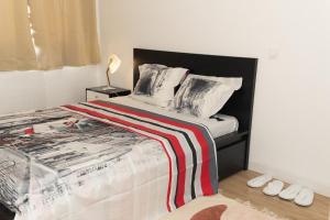 een slaapkamer met een bed met een rood-witte deken bij The Zen Space in Athis-Mons