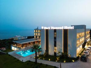 a hotel with a pool in front of a building at Black Diamond Hotel Dhermi in Dhërmi