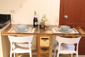 a kitchen with a counter with two bowls and two chairs at StoryStays City Pod - Entire Unit at the heart of Cebu in Cebu City