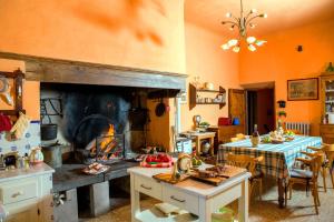 a kitchen with a large fireplace with a table and a table sidx sidx at Villa i Lecci - The Gate of Chianti in Poggio Alla Croce