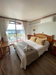 a bedroom with a large bed with towels on it at Hotel Encanto del Río in Valdivia