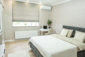 a bedroom with a bed and a desk and a window at Comfortable Living- Free Coffee, Netflix & More - GrandStay md in Chişinău