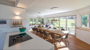 a kitchen and dining room with a long table and chairs at Villa Bellevue Altaussee in Altaussee