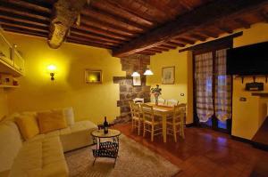Una sala de estar con un sofá blanco y una mesa. en Cottage Le Ginestre con piscina in Val d'Orcia, en Radicofani