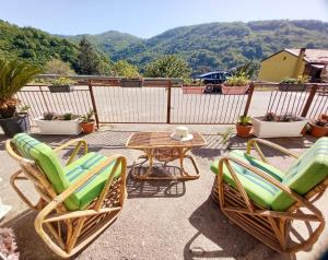 a patio with two chairs and a table with a view at Casa delle Tholos in Raccuia