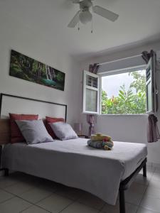 Un dormitorio con una cama grande con ventana. en Gîte Ti jit la, en Saint-Claude