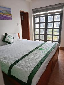a large bed in a room with a large window at Thành Hưng Motel in Hà Tiên