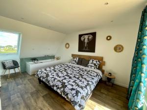 a bedroom with a bed and an elephant picture on the wall at Grande maison à 200m de la plage in Plouguerneau +12 photos