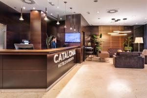 a woman standing at a counter in a hotel lobby at Catalonia El Retiro in Madrid +28 photos