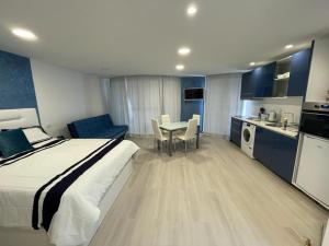 a bedroom with a bed and a table and a kitchen at Center Marina view Blue Studio in Funchal