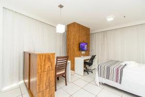 ein Hotelzimmer mit einem Bett und einem Schreibtisch mit einem Computer in der Unterkunft Fusion Hotel em Brasília 09954 in Brasilia