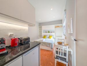 a kitchen and a bedroom with a bed in a room at Casas das Hortas, Studio Vista Jardim e Serra in Seixal
