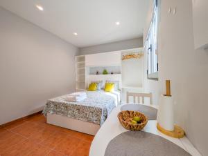 a bedroom with a bed and a table with a basket on it at Casas das Hortas, Studio Vista Jardim e Serra in Seixal