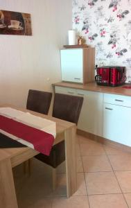 eine Küche mit einem Holztisch, Stühlen und einer Theke in der Unterkunft Lutherdom Apartment in Lutherstadt Eisleben