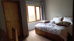 a bed in a room with a window and a bed sidx sidx sidx at Tsogstot residency in Deskit