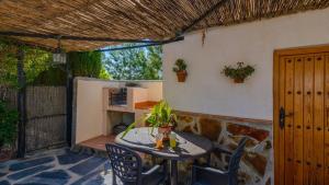 a patio with a table and chairs and a building at Cortijo El Olivar Órgiva by Ruralidays in Órgiva