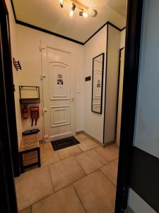 a hallway with a white door and a tile floor at Eco-Logis le 50, maison avec jardins et terrasse privatifs in Mondeville +46 photos