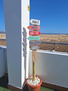 a pole with a bunch of signs in a pot at Villadunas - with Luxury Hot Tub and Tiki Roof Top Bar in Corralejo