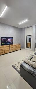 Un dormitorio con un televisor de pantalla plana en la pared. en Ново! New Studio PANDORA, en Sliven