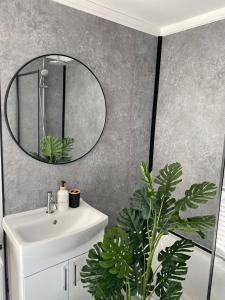 ein Badezimmer mit Waschbecken und Spiegel an der Wand in der Unterkunft Modern Townhouse-Free Parking-Games Room-Fast W-iFi in Manchester