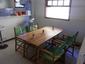 einen Holztisch mit grünen Stühlen in der Küche in der Unterkunft Casa 2 Recreio De Buzios 1 - casa em condomínio com vista para o mar in Búzios